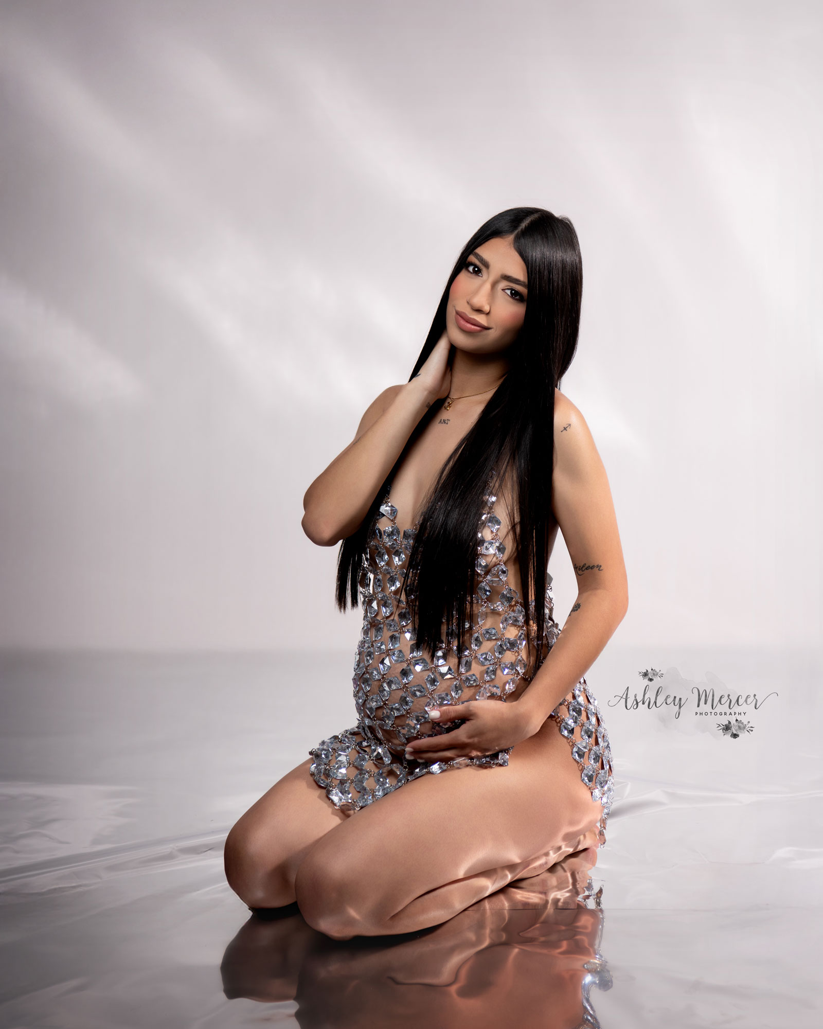 Mom to be wearing a jeweled gown during a maternity photo shoot