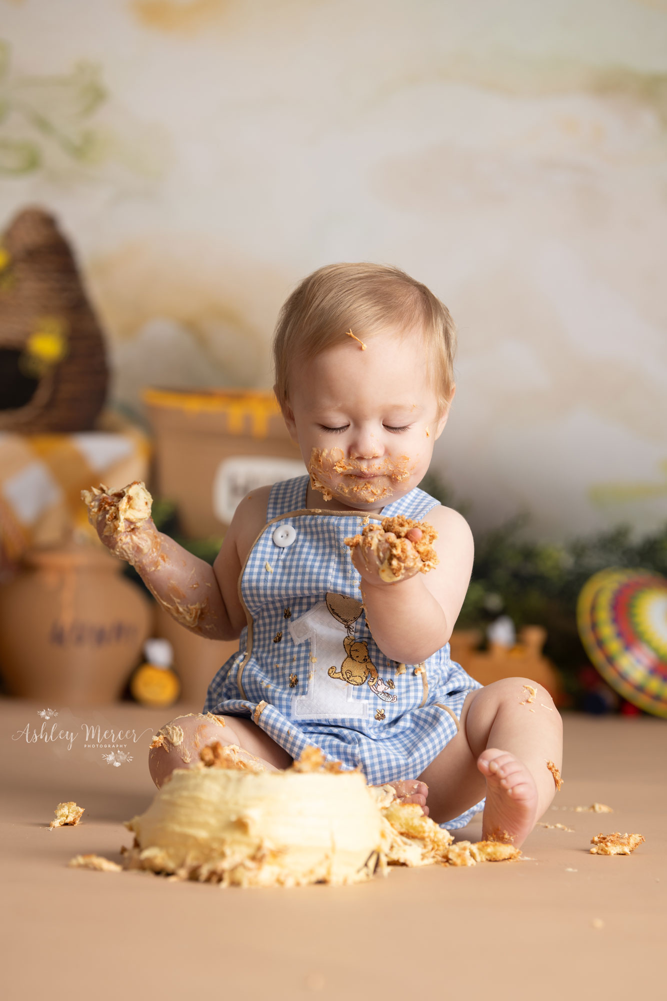 One year old smashing his cake during a Winnie the Pooh themed photography session